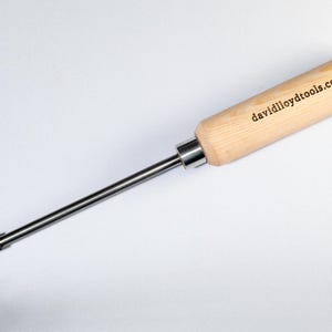 Puede incluir: Una herramienta con mango de madera, un eje de metal y una punta cuadrada pequeña. El mango está grabado con el texto "davidlloydtools.com".