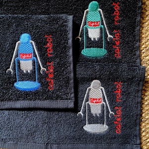 May include: Three black hand towels with embroidered images of a robot holding a coffee cup. The text "cafelet robot" is embroidered in red on each towel.