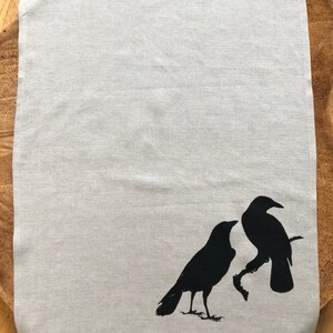 以下が含まれることがあります： グレーのリネン製のティータオルに、黒いシルエットの2羽のカラスがプリントされています。