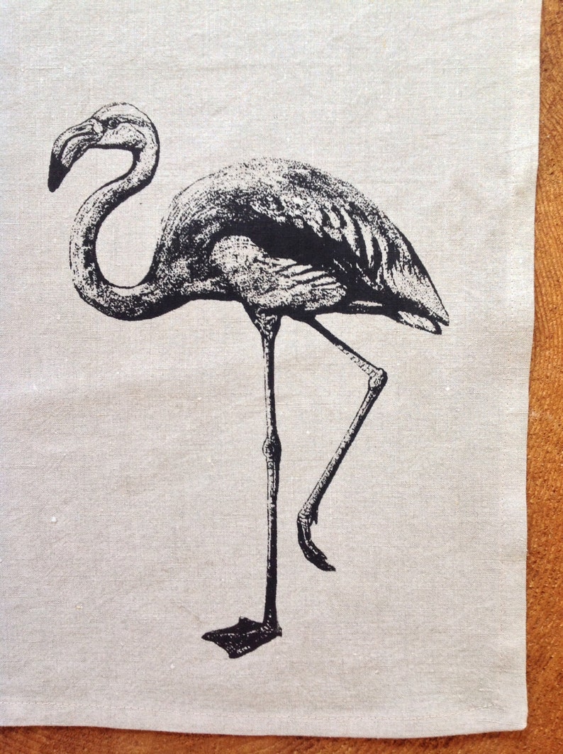 May include: Black and white illustration of a flamingo standing on one leg on a beige background.