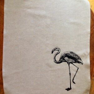 May include: A white linen tea towel with a black and white illustration of a flamingo.