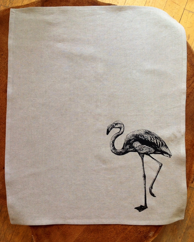 May include: A white linen tea towel with a black and white illustration of a flamingo.