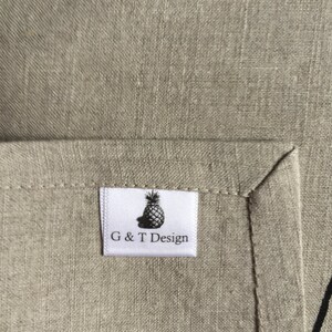 May include: A white fabric label with a black pineapple graphic and the text "G & T Design".