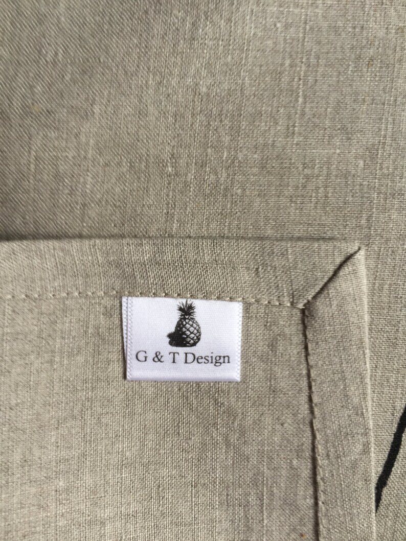 May include: A white fabric label with a black pineapple graphic and the text "G & T Design".