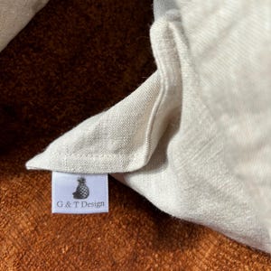 Pode incluir: Uma bolsa tote de linho branco com uma etiqueta branca que diz "G & T Design" e um gr&aacute;fico de abacaxi preto.