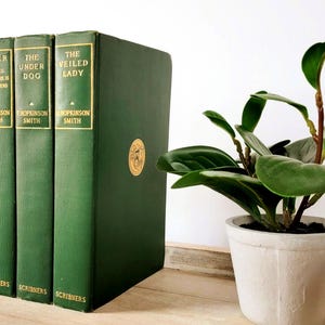 May include: Four green hardcover books with gold lettering on the spines. The titles are "The Fortunes of Oliver Horn", "Peter", "The Under Dog", and "The Veiled Lady". The books are all by the author "Chopkinson Smith" and published by "Scribners".