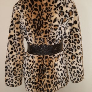 May include: A brown, black, and white leopard print faux fur coat with a black studded belt.