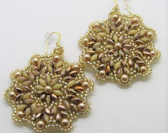 May include: A pair of gold tone earrings with a delicate design of beige and copper beads. The earrings are shaped like a starburst and have a dangling design.