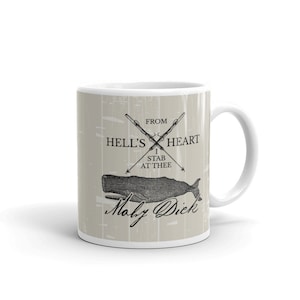 May include: White ceramic mug with a beige background featuring a black and white illustration of a whale with crossed harpoons and the text "From Hell's Heart I Stab At Thee" and "Moby Dick".