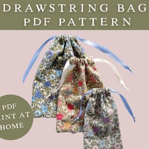May include: Three drawstring bags with floral patterns and light blue or white ribbons. The bags are in shades of blue, pink, and brown. Text at the top reads "DRAWSTRING BAG PDF PATTERN". A green circle with the text "PDF PRINT AT HOME" is in the lower left.
