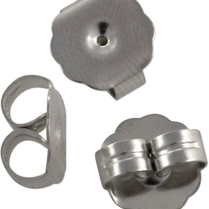 May include: Three silver earring backs. The backs are made of metal and have a rounded shape. They are designed to fit over the post of an earring.