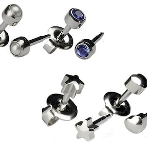 May include: A set of six silver stud earrings with different designs. The earrings feature a pearl, a blue gemstone, a star, and a heart.
