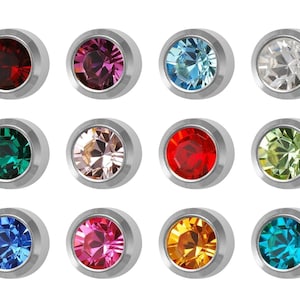 May include: Twelve silver-toned earring studs with different colored gemstones. The gemstones are red, pink, blue, green, clear, and yellow.