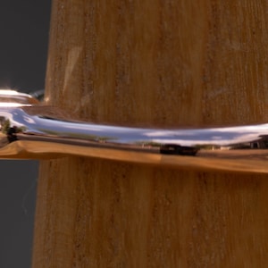 May include: A rose gold ring with a single, clear, round diamond set in a prong setting.