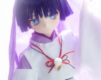 May include: A doll with blue hair and blue eyes wearing a white kimono with a purple scarf. The doll has a red and black ribbon tied around its neck.