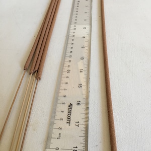 May include: A bundle of brown incense sticks with a ruler measuring 18 inches long. The incense sticks are approximately 17 inches long.
