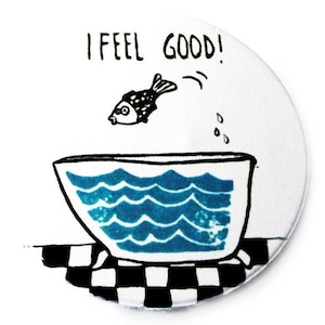 Könnte beinhalten: Ein runder weißer Untersetzer mit einem schwarz-weißen Schachbrettmuster am Rand. Eine Schwarzweißillustration eines Fisches, der aus einer blauen Badewanne springt, mit dem Text "I feel good!" über der Badewanne.