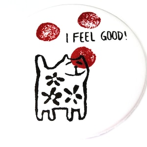Könnte beinhalten: Weißer Keramikuntersetzer mit einer Schwarzweißillustration einer Katze mit Blumen auf ihrem Körper. Die Katze schaut zu drei roten Kreisen auf. Der Text "I FEEL GOOD!" ist in Schwarz über der Katze geschrieben.
