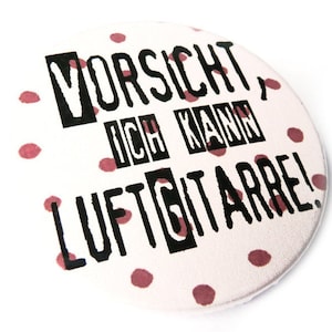 Button, magnet, pocket mirror, bottle opener air guitar