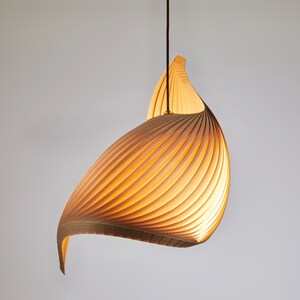 K&ouml;nnte beinhalten: Eine Holz-Pendelleuchte mit einem einzigartigen, geschwungenen und spiralf&ouml;rmigen Design. Die Leuchte besteht aus d&uuml;nnen Holzlamellen, die ein warmes, nat&uuml;rliches Aussehen erzeugen.
