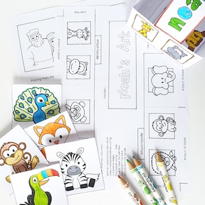 May include: A printable Noah's Ark craft activity for kids. The craft includes a base, handle, and animal cutouts. The animals include a monkey, zebra, toucan, fox, peacock, giraffe, panda, elephant, and a monkey. The craft is designed to be assembled by attaching the pieces together.