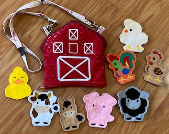 May include: A red barn-shaped felt bag with a zipper closure and a strap. The bag is filled with felt animal finger puppets, including a cow, horse, pig, sheep, rooster, chicken, and duck.