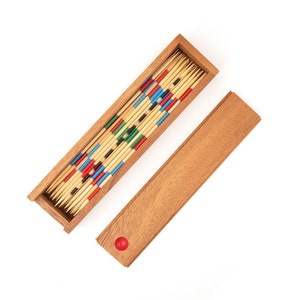 May include: A wooden box filled with colorful wooden sticks. The box is open and the sticks are arranged in a pattern. The box is on a white background.