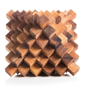 May include: A wooden puzzle made of many small, interlocking cubes. The puzzle is in the shape of a diamond and is made of a light brown wood.