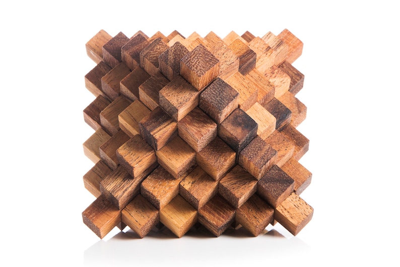 May include: A wooden puzzle made of many small, interlocking cubes. The puzzle is in the shape of a diamond and is made of a light brown wood.