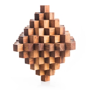 May include: A wooden puzzle made of many small, interlocking cubes. The puzzle is shaped like a diamond and is made of light and dark brown wood.