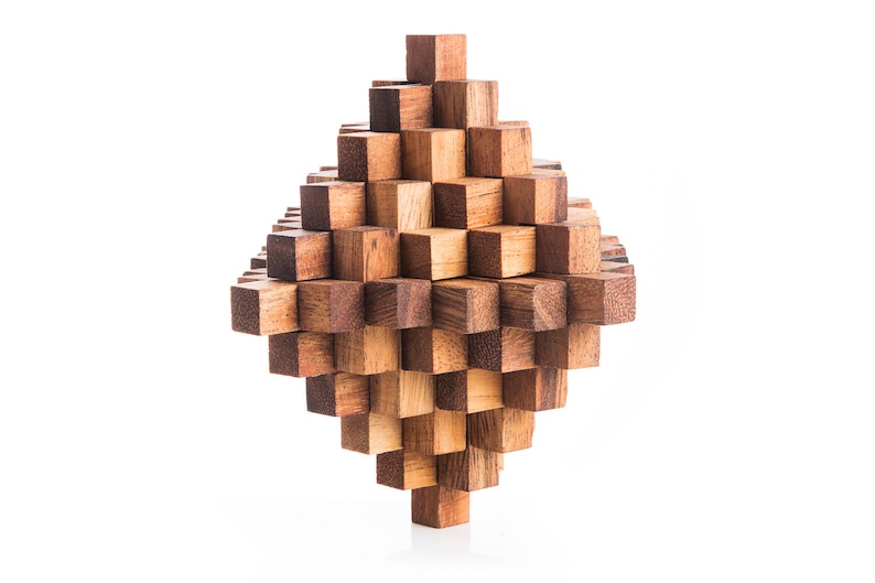 May include: A wooden puzzle made of many small, interlocking cubes. The puzzle is shaped like a diamond and is made of light and dark brown wood.
