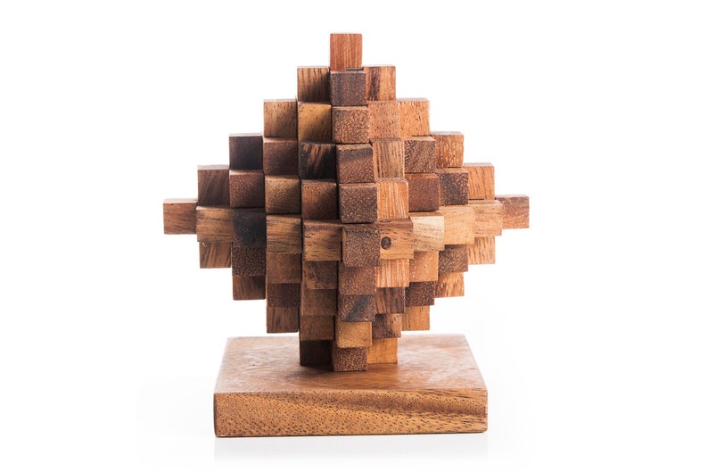 May include: A wooden puzzle in the shape of a diamond, made of many small wooden blocks. The puzzle is assembled and sits on a wooden base.