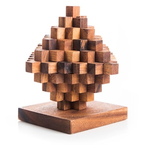 May include: A wooden puzzle in the shape of a diamond, made of many small interlocking pieces. The puzzle is assembled and sits on a wooden base.