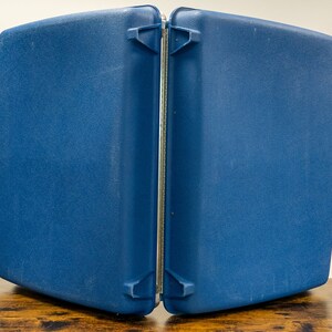 May include: A blue, hard-sided, two-piece suitcase with a silver zipper and clasps.