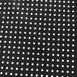 K&ouml;nnte beinhalten: Schwarzer Stoff mit einem sich wiederholenden Muster aus gleichm&auml;&szlig;ig verteilten wei&szlig;en Punkten. Die kleinen, kreisf&ouml;rmigen Punkte erzeugen ein klassisches Design. Dieser Stoff eignet sich f&uuml;r verschiedene N&auml;h- und Bastelprojekte.