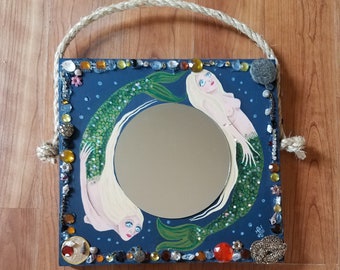 Mermaid mirror hand painted on reclaimed wood with gems, seashells and vintage buttons around the edges and rope hanger