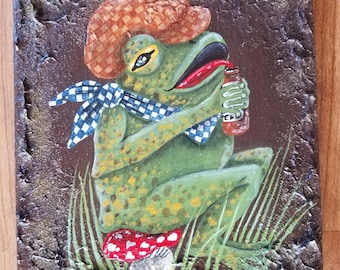 Frosch trinkt ein Bier, während er auf einem Perlenhocker sitzt. Handbemalt auf altbemaltem Holz mit strukturierter Bemalung