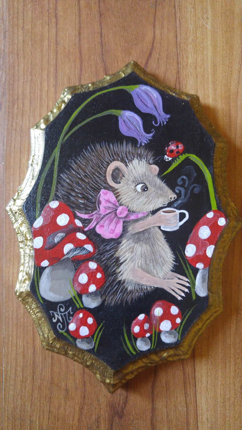 Hedgehog drinking a cup of tea sitting amongst magic mushrooms and bluebells Hand painted on decorative wood piece