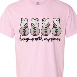 Puede incluir: Camiseta rosa con cuatro pollitos Peep con temática de béisbol y el texto "hanging with my peeps".