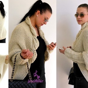 May include: A beige knitted cardigan with a draped design and long sleeves. The cardigan is shown being worn by a person with a black top and jeans.