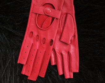 May include: A pair of red leather driving gloves with fingertip holes and a strap with a button closure.