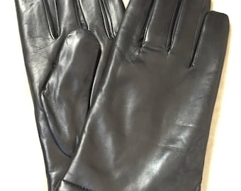 Op de afbeelding: Een paar zwarte leren handschoenen. De handschoenen zijn dubbelgevouwen en de vingertoppen zijn zichtbaar.