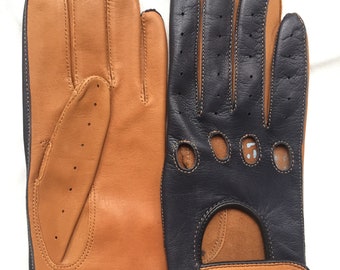 May include: A pair of leather driving gloves in black and brown. The gloves feature a perforated design and a strap on the wrist.
