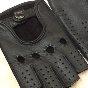 May include: A pair of black leather fingerless gloves with a button closure and a perforated design.
