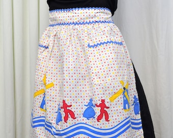 Vintage 1950s kitchen half apron in red, blue, yellow on white with flowers, Dutch couple, and windmills print