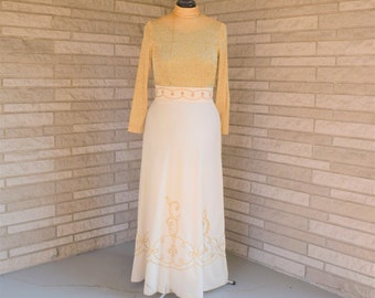 Vintage 1960s 1970s floor length maxi gown gold metallic knit long sleeve bodice off white cream skirt with gold soutache trim