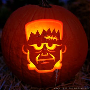 May include: A carved orange pumpkin with a glowing Frankenstein face. The face is lit from within, showcasing the character's iconic features, including stitched scars and jagged hair. The pumpkin is a festive Halloween decoration.