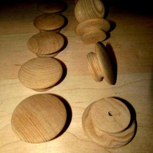 May include: A collection of eight wooden knobs with a natural wood finish. The knobs are round and have a smooth surface. They are perfect for adding a rustic touch to any home decor project.