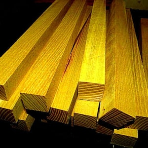 May include: A stack of yellow wooden dowels, likely for crafts or woodworking projects.