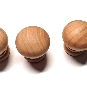 May include: Three wooden knobs with a natural wood finish. The knobs are round and have a slight indentation in the center. They are perfect for adding a rustic touch to any home decor project.